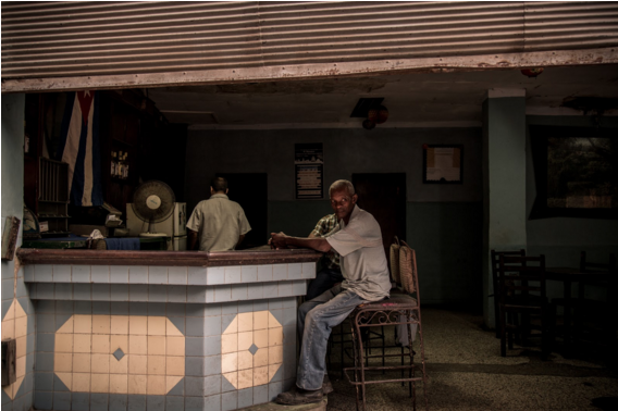 Pockets of light in Cuba man sitting at a bar