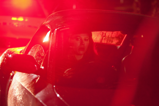 Woman in car shot under street lights