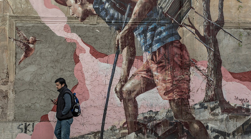 Person walking in front of a mural in Columbia taken by Gina Milicia
