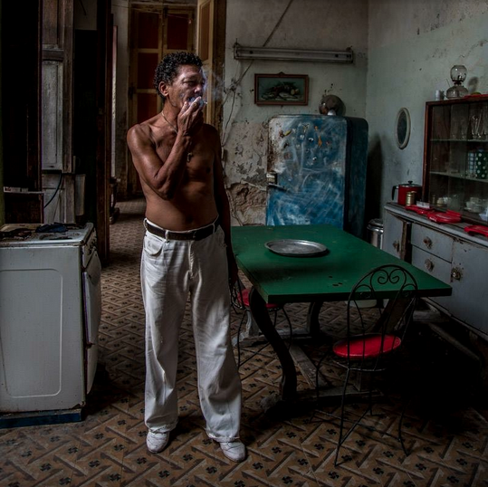 shirtless cuban guy smoking in his kitchen
