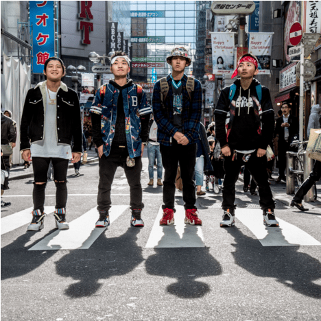 Photo of four young men standing in an intersection in Shibuya Japan