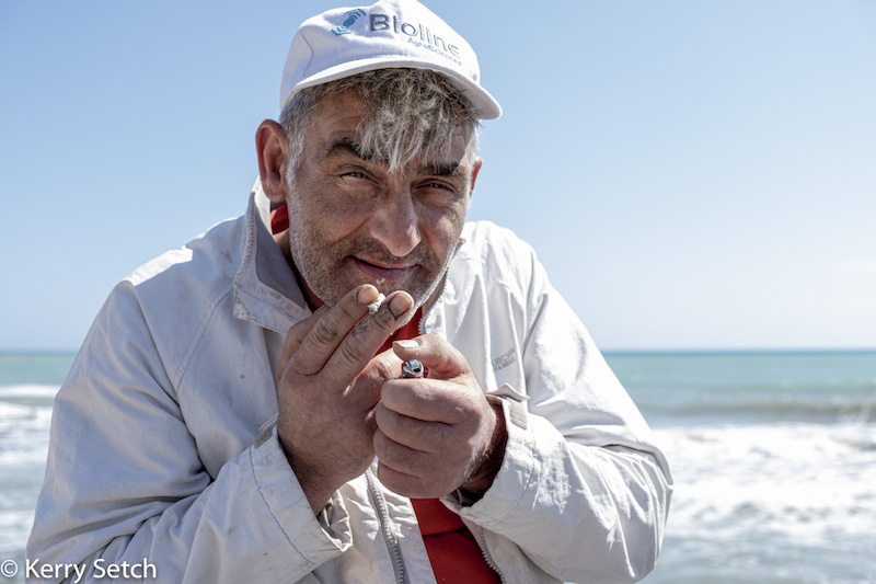 Man with cigarette in front of the beach by Kerry Setch