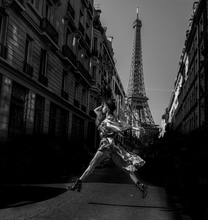 woman leaping in a Paris street Eifel tower in background